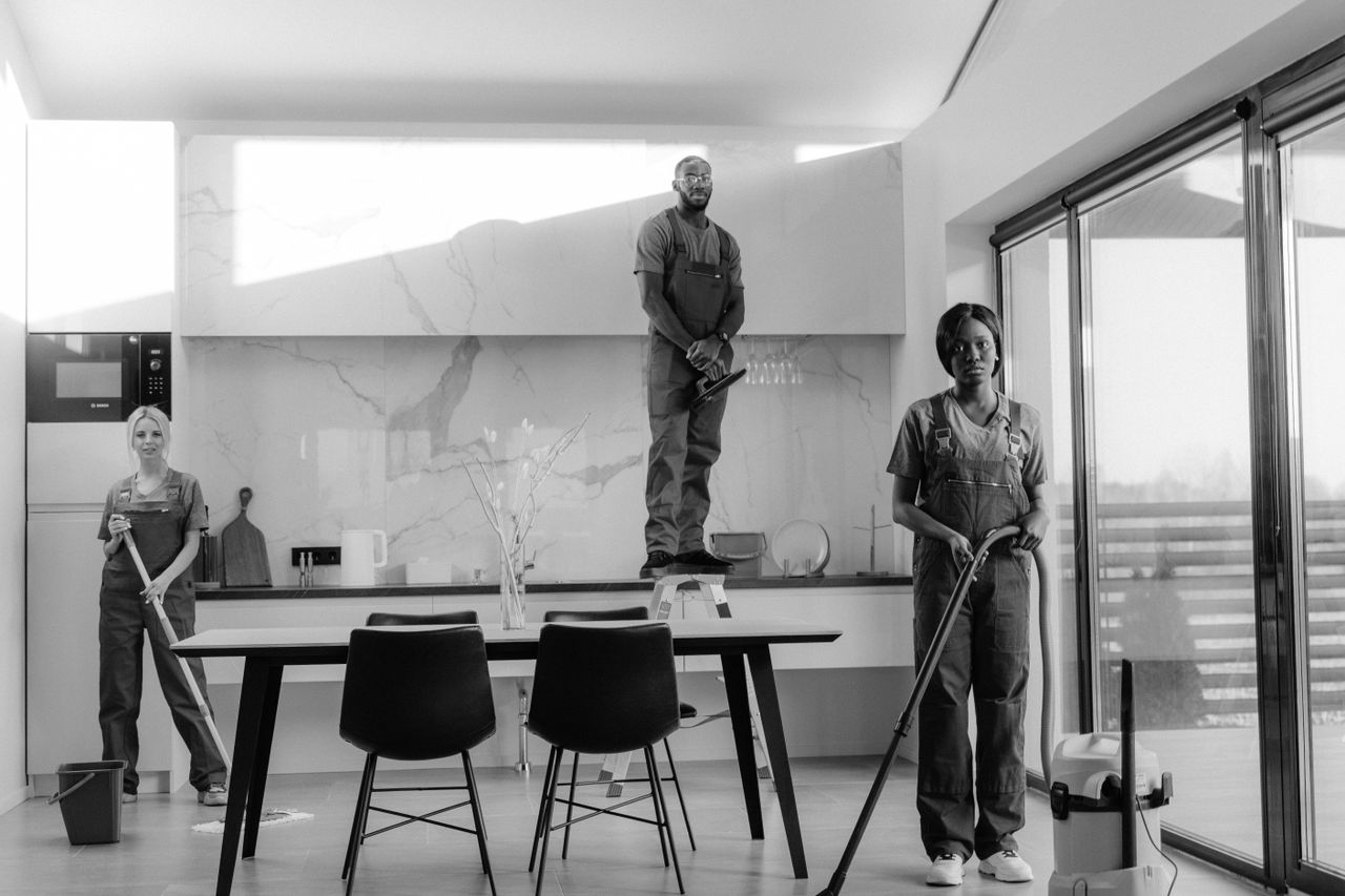Home A team of professional cleaners working in a modern dining room setting, enhancing interior cleanliness.